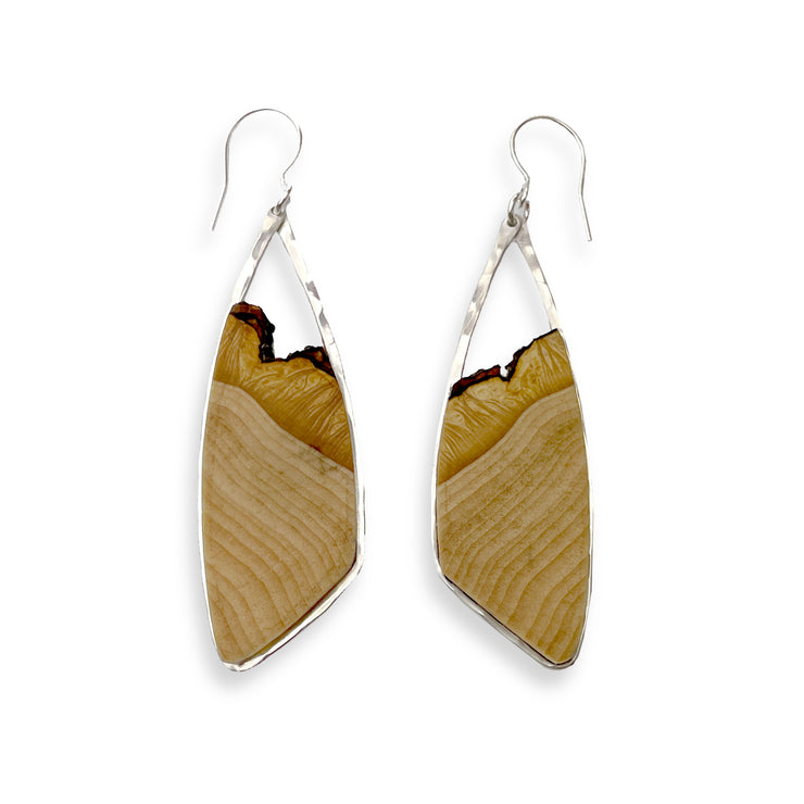 Hand-cut basswood framed in your choice of hand-forged sterling silver or 14k gold-fill. These woody pieces measure 2.5" from the bottom of the ear wire to the bottom of the earring and just under 1" from side-to-side. 